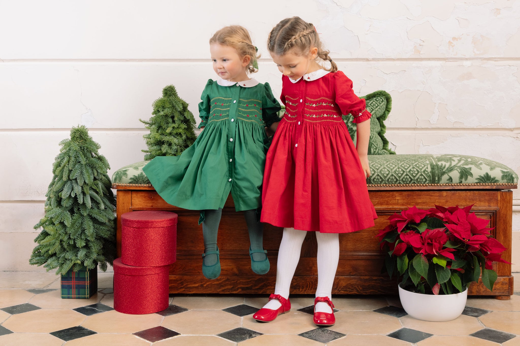 Girls wearing red and green Christmas smocked dresses
